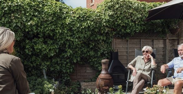 Parents and their daughter socially distant in the garden.